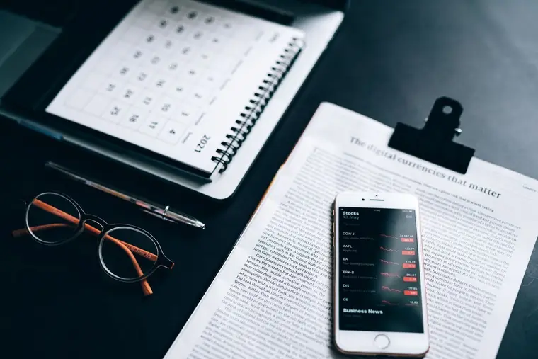 Kalendarz, telefon i okulary na biurku