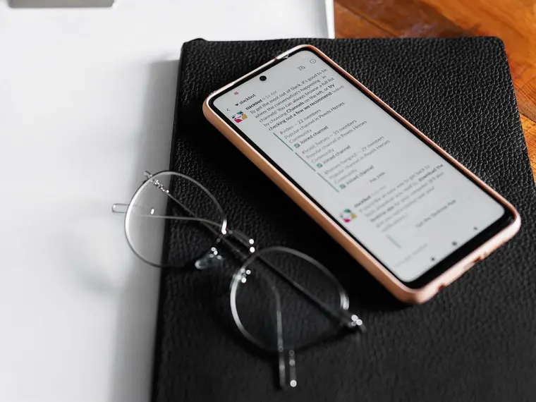 Telefon i okulary na czarnym notesie
