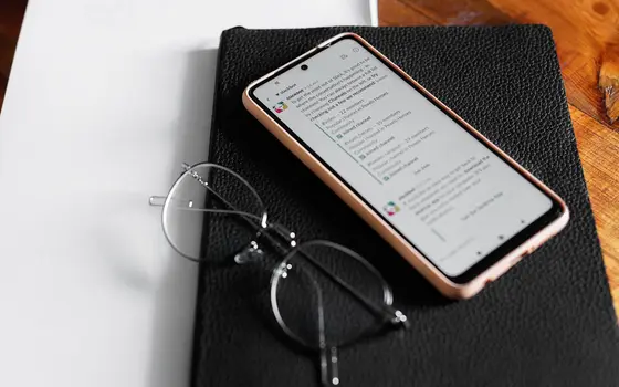Telefon i okulary na czarnym notesie