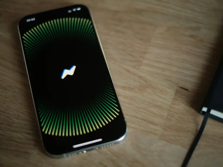 Telefon z animacją asystenta głosowego na drewnianym biurku